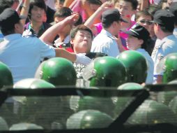 Un ciudadano chino lanza una piedra afuera de la embajada de Japón en Beijing, en el 81 aniversario del “Incidente de Mukden”. EFE  /