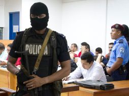 Un policía nicaraguense custodia a los 18 falsos periodistas durante una audiencia, en la que la Fiscalía acusó a los detenidos. XINHUA  /