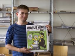 El director de publicaciones del semanario satírico Charlie Hebdo, muestra la portada del número con las caricaturas de Mahoma. AFP  /