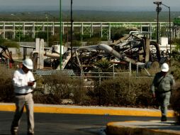 Trabajadores de la paraestatal caminan por el área del incendio. AFP  /