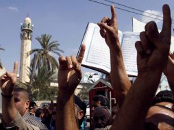 Algunos de quienes salen a las calles cargan ejemplares de El Corán. AP  /