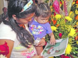 Despedida. Esposa e hija dan el último adiós a uno de los trabajadores fallecidos en la explosión. AFP  /