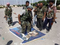 Rebeldes sirios pisotean una imagen del presidente Bashar Assad. AP  /