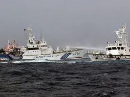 Un barco de la guardia costera japonesa (c) usa un cañón de agua contra una embarcación de su homóloga taiwanesa. EFE  /