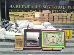 Cargamento. Policías estatales aseguran droga, armas, vehículos y una imagen de Jesús Malverde.  /