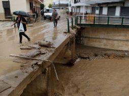 Residentes caminan por las calles después de las fuertes lluvias. AP  /