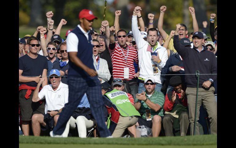 Tiger Woods festeja junto con el público en el campo de golf. EFE  /