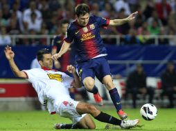 Lionel Messi se quita la entrada de Spahic del Sevilla. AP  /