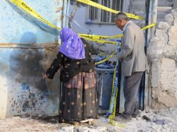 arios residentes turcos revisan el estado de una casa que recibió el impacto de un obús, lanzado desde Siria. EFE  /