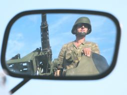 ALERTA. Un soldado turco se refleja en un espejo, mientras hace guardia sobre un vehículo blindado en la frontera turco-siria. REUTERS  /