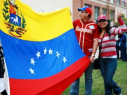 Un grupo de jóvenes muestran una bandera de Venezuela a las afueras del Centro de Convenciones de Nueva Orleans. EFE  /