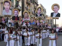 Manifestantes coptos sujetan fotos de las víctimas asesinadas durante los enfrentamientos de Maspero. EFE  /