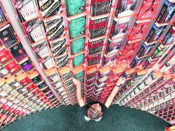 Una mujer coloca libros en un estante gigante antes de la inauguración de la más grande feria del libro del mundo, en Fráncfort. AP  /