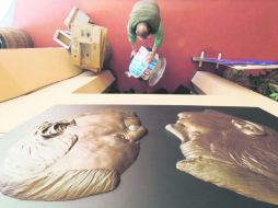 Un trabajador pasa debajo del relieve de una escultura de Joe Biden (izquierda) y Paul Ryan, en el Centre College, en Danville. AP  /