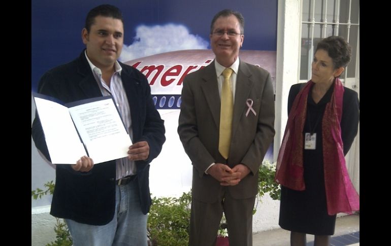 La Cónsul General de EU le otorga a Jorge Maldujano (i), un solicitante de visa, dos boletos de avión gratuitos donados por AA.  /