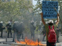 Un manifestante sostiene una pancarta con consignas frente a policías antidisturbios. XINHUA  /