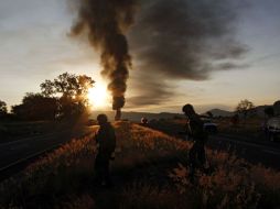 La columna de humo es menor, pero el fuego sigue presente. Bomberos trabajan para evitar que el incendio afecte a la vegetación. XINHUA  /