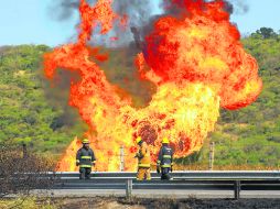 ''Infierno'' en la tierra. Bomberos trabajan en el gasoducto averiado, en el kilómetro 461 de la autopista a Morelia.  /