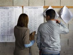 Dos votantes gallegos buscan información en las casillas electorales. AP .  /