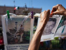 Las madres muestran las fichas de sus hijos para tratar de localizarlos. XINHUA  /