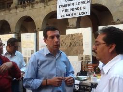 Miguel Castro (izq) habla con los trabajadores quejosos quienes habían montado plantón en el patio central del Legislativo.  /