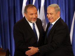 El primer ministro israelí, Netanyahu (d), y el ministro de Exteriores, Lieberman (i), se abrazan tras anunciar su alianza. EFE  /