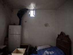 Un rebelde sirio vigila a través de una ventana los movimientos del ejército del régimen. AFP  /