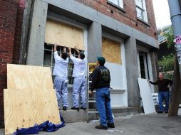 Residentes refuerzan sus viviendas con tablas de madera, como medida de precaución por el paso del huracán Sandy en Nueva York. XINHUA  /