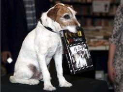 Uggie, sosteniendo su biografía durante la presentación del libro en Londres. AP  /