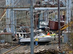 Trabajadores hacen labores para remover botes y escombro de una vía de tren en Nueva Jersey. AP  /