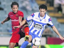 Desaparecido. Giovani, del Mallorca, disputa un balón con Roderick Miranda, del Deportivo. ESPECIAL  /