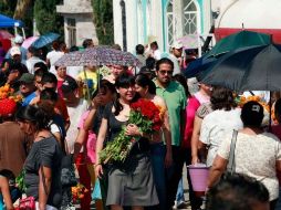 Miles de personas asisten a los cementerios en el marco de la celebración del Día de Muertos.  /
