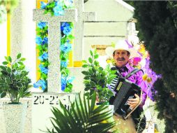 Ambiente alegre. En el Panteón de Mezquitán, un hombre interpreta una pieza que en vida el difunto prefería.  /