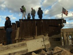 Personas se paran en los restos destruidos en el barrio de Queens en Nueva York. AFP  /