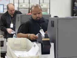Trabajadores escanean votos enviados por correo en el Miami-Dade County. AP  /
