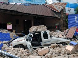 Vehículos quedaron aplastados por la caída  de muros en San Marcos. AP  /