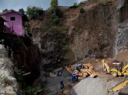 Rescatistas laboran en una zona donde se presentaron deslaves. AP  /