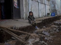 Un niño espera sentado entre los escombros que dejó el sismo. EFE  /