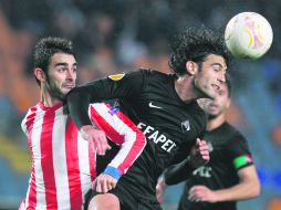 Anticipa. El defensa del Académica de Coimbra, Joao Real, gana un balón por aire al mediocampista del Atlético, Adrián López. AP  /