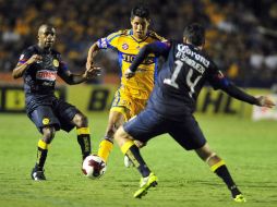 Hugo Ayala (c) de Tigres disputa el balón con Christian Benitez (i) y Rubens Sambueza (d) de América. EFE  /
