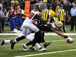 Colston, de los Santos, se estira para anotar en el partido. AP  /