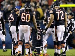 Cutler de los Osos de Chicago es auxiliado por sus compañeros luego de ser derribado. AP  /