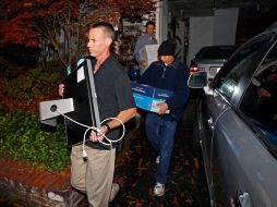 Agentes del FBI llevan cajas y una computadora de la acas de Paula Broadwel. AP  /