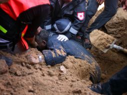 Rescatistas palestinos intentan sacar a un hombre atrapadol después de un ataque aéreo israelí. XINHUA  /