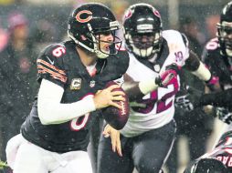 Huye. Jay Cutler elude la marca de los defensivos de Houston, durante el partido donde salió lesionado. AP  /