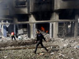 Un bombero intenta apagar el fuego que provocó el ataque aéreo israelí a un edificio de Gaza. AP  /