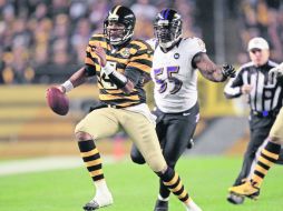 Byron Leftwich, quien elude la presión de Terrell Suggs, corre hacia las diagonales, en la jugada donde resultó lesionado. AP  /