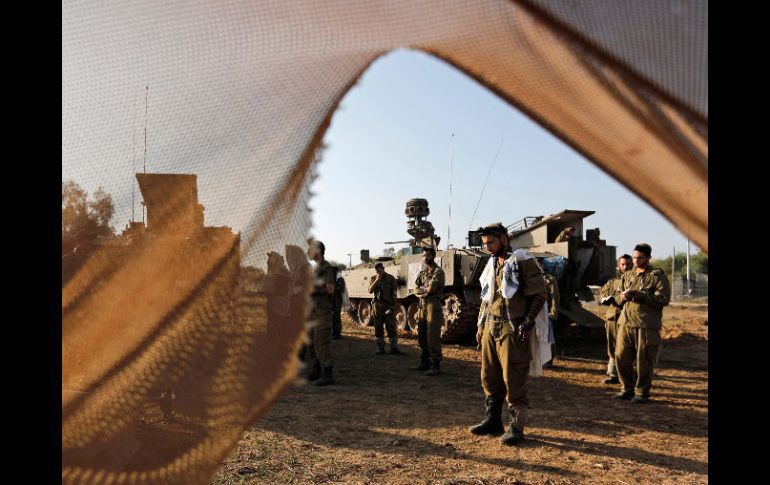 Soldados israelíes oran antes de intervenir en el conflicto palestino-israelí. AP  /