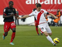 El centrocampista del Rayo Vallecano, Francisco Luna ''Piti'' (d), golpea la pelota ante la presión de Michael Pereira (i). EFE  /