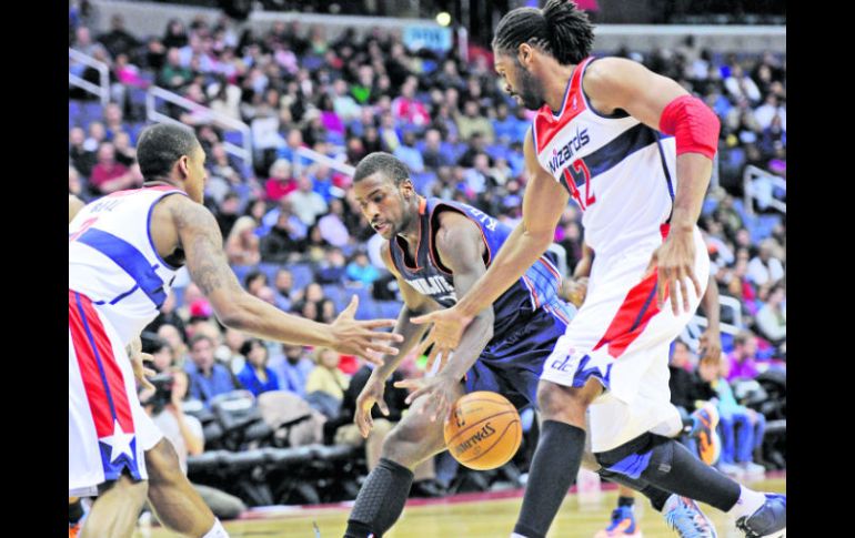 Para nadie. Nené y Bradley Beal (de blanco) pelean la pelota con Michael Kidd. AP  /